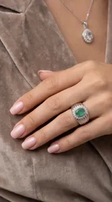 Anillo de plata 925 con diseño robusto, presenta una piedra central ovalada de esmeralda rodeada por un halo de circonias brillantes.