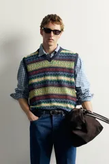 Chaleco regular fit de punto tejido en hilatura de lino, con diseño de patrones geométricos multicolor en tonos azul, verde, amarillo y rojo. Presenta cuello en V, manga sisa y acabados en rib. Colección especial Aaron Levine x Zara.
