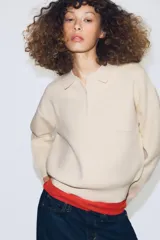 Jersey de punto con cuello tipo polo, manga larga con puños y cierre frontal con botones. Presenta un bolsillo de plastrón en el pecho y diseño de corte holgado.