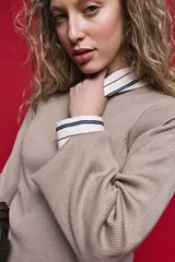 Sweater de punto rib color tostado, con hombros estructurados y mangas abullonadas con puños elásticos.