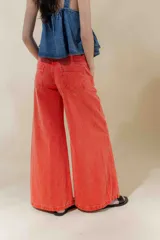 Pantalón de jean de tiro medio y pierna ancha, confeccionado en denim 100% algodón. Diseño con 5 bolsillos y pespuntes a contratono.