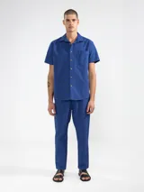 Camisa azul de manga corta confeccionada en algodón ligero con textura waffle. Presenta corte cuadrado, bolsillo en el pecho y botones de coco grabados con el logo de Polonio.