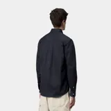 Camisa de manga larga con cuello abotonado, confeccionada en tejido de algodón resistente. Presenta un corte clásico, cierre frontal con botones y el logo de la marca bordado en el pecho.