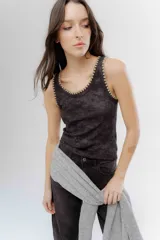 Musculosa de algodón y viscosa en color gris oscuro con efecto lavado, presenta un delicado bordado en hilo lurex dorado en el contorno del cuello y las sisas.