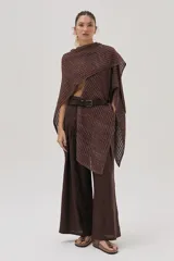 Ruana tejida con textura acanalada y destellos de lurex, de diseño asimétrico y caída fluida, ideal para superponer sobre diferentes prendas.