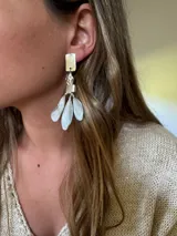 Aros colgantes plateados con forma geométrica y hojas.