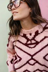 Sweater de punto oversize con diseño jacquard geométrico en tonos gris y crema. Presenta cuello redondo a la base, mangas largas y terminaciones en punto elástico acanalado.