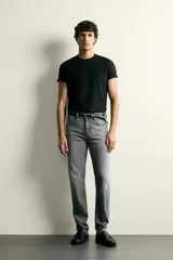 Jeans slim fit de color negro para hombre, con tiro medio, diseño de cinco bolsillos y cierre frontal con cremallera y botón.