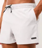 Bermuda de running Get Over para hombre, confeccionada en microfibra ligera de color gris claro. Presenta cintura elástica con cordón ajustable, bolsillos funcionales, dobladillo redondeado con aberturas laterales y pequeño parche con logo de la marca en la pierna izquierda.