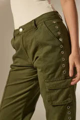 Pantalon cargo de algodón color gris oscuro, de tiro alto y corte recto. Presenta bolsillos laterales tipo cargo y una hilera de ojales metálicos decorativos a lo largo de la pierna derecha.