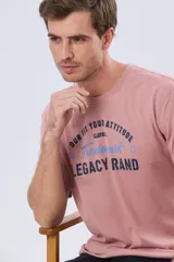 Remera verde pistacho de manga corta y cuello redondo, con diseño gráfico estampado en el frente con inscripciones y tipografías en tonos oscuros y blancos.