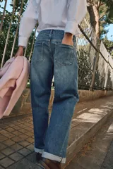 Pantalón de jeans estilo relaxed fit, de tiro alto, color azul con efecto lavado y botamanga con vuelta. Cuenta con cinco bolsillos, trabillas para cinto y cierre frontal con cremallera y botón metálico.