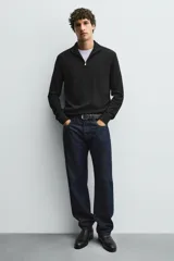 Bota Chelsea de cuero marrón, con punta fina y elásticos laterales oscuros. Posee un tirador trasero y un taco bajo y cuadrado.