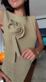 Vestido midi de lurex marrón con brillo sutil, cuello a la base, sin mangas, con apliques de flores en relieve y tajo lateral en la falda.