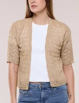 Bolero corto de punto beige, con diseño abierto sin botones y mangas cortas. Presenta un patrón de tejido calado con detalles geométricos y terminaciones onduladas en los bordes.