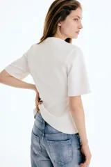 Remera manga corta de interlock pesado color blanco, con cuello redondo y diseño entallado en la cintura con pinzas moldeadoras frontales.