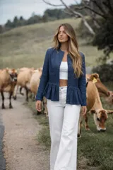 Chaqueta de denim azul con cuello mao, corte elegante, volados delicados y botones forrados en el mismo tejido.