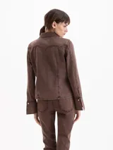 Camisa entallada confeccionada en denim de algodón con lavado marrón chocolate, cuello camisero, cierre frontal con botones y recortes verticales.