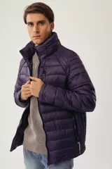 Campera puffer de diseño acolchado en color azul oscuro, con cuello elevado, cierre frontal completo y bolsillos laterales con cierre. Incluye un bolsillo adicional en el pecho y capucha oculta.