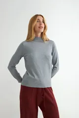 Polera de punto color beige, con cuello alto y mangas largas, de diseño básico y ajuste clásico.