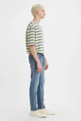 Jean de corte skinny con tiro medio, confeccionado en denim azul con efecto de lavado desgastado.