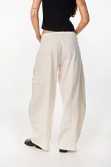 Pantalón cargo color beige de tiro bajo y corte ancho, con bolsillos laterales utilitarios.