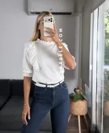Blusa de símil lino color beige, con cuello redondo fruncido, doble volado en los hombros con detalle de encaje y manga 3/4.