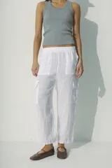 Pantalón de lino blanco, de corte recto y tiro alto, con bolsillos laterales y traseros.