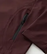 Campera deportiva Get Over de tejido técnico resistente al agua, color bordó. Presenta capucha ajustable con cordones, cierre frontal con cremallera, bolsillos laterales y un bolsillo adicional en el pecho, todos con cierre.