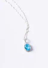 Collar de plata 925 con cadena de eslabones retorcidos y dije ovalado con piedra central color turquesa rodeada de zirconias brillantes.