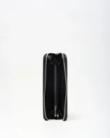 Billetera tipo fichero XL Extra Large, color negro y blanco con diseño texturizado, cierre perimetral y correa de mano. Incluye el logo de la marca en metal plateado en el centro.