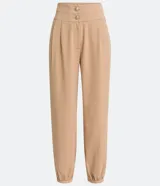 Pantalón zanahoria color beige de crepé con cinturilla ancha, botones con forma de león y pinzas delanteras.