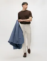 Pantalon de lino color beige, de corte recto con bolsillos delanteros y traseros con cierre de botón.