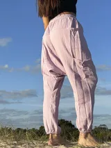Pantalón babucha de muselina color lila, con cintura elástica y bolsillos laterales.