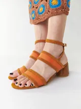 Sandalias de tacón bajo y redondo, con diseño de tiras finas en gamuza y paneles laterales de material translúcido. Cuentan con cierre de pulsera ajustable al tobillo.