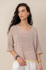 Sweater de tejido de punto a rayas horizontales en tonos beige y blanco, con escote en V y mangas cortas holgadas.