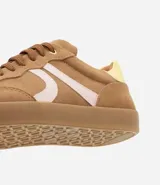 Championes de mujer estilo chuteira, color verde oscuro con detalles en blanco y suela de goma color caramelo. Presentan un diseño de corte bajo con cordones y un logo lateral en forma de arco.