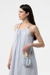 Vestido midi celeste de calce amplio y liviano, con escote fruncido regulable y breteles finos con detalles de cuentas. Presenta una silueta suelta e incluye una mini cartera desmontable al tono.