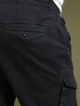 Pantalón cargo negro de sarga de algodón con spandex, con bolsillos laterales con solapa y etiqueta con el logo de la marca en uno de ellos.