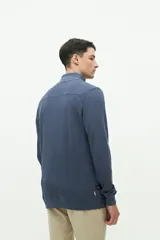 Buzo azul de felpa con medio cierre frontal, cuello alto y logo de goma en el pecho.