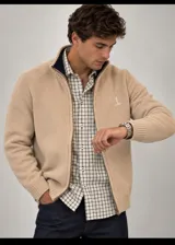 Cardigan de punto color beige, con cierre frontal y cuello alto con interior azul marino.