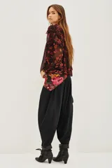 Pantalón tipo babucha de corte holgado y tiro alto, con cintura elástica y diseño de pierna amplia que se estrecha hacia los tobillos.