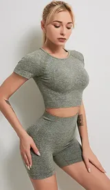 Conjunto deportivo color borgoña jaspeado, compuesto por un top con espalda deportiva y unos shorts ajustados de tiro alto.