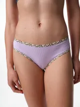 Bombacha tipo bikini de tiro medio confeccionada en algodón acanalado blanco, con bordes terminados en ribete con estampado animal print.