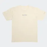 Remera de algodón color hueso con corte regular. Presenta un pequeño estampado con el texto 'Wasted Talent' en el centro del pecho y un detalle de costura en forma de 'W' en la manga izquierda.