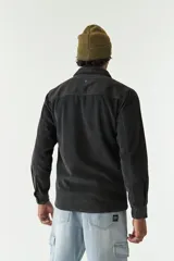 Sobrecamisa de pana color beige, con cuello clásico, cierre frontal de botones y bolsillos tipo cartera en el pecho.