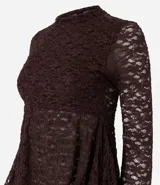 Blusa de encaje color bordó con trama floral y transparencia. Presenta cuello medio, mangas largas ajustadas y un recorte debajo del busto que genera un efecto peplum con volados en el dobladillo.