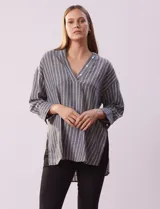 Blusa de poliéster con estampado de rayas verticales, cuello en V con botones, mangas tres cuartos y tajos laterales.