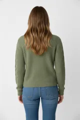 Sweater de punto acrílico color crema, con cuello redondo y diseño de punto trenzado (cable knit) en todo el cuerpo y mangas.