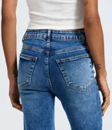Pantalón de jean azul con corte recto y tiro alto. Presenta un acabado con efecto marmorizado, trabillas en la cintura, cierre frontal con botón y bolsillos laterales y traseros.